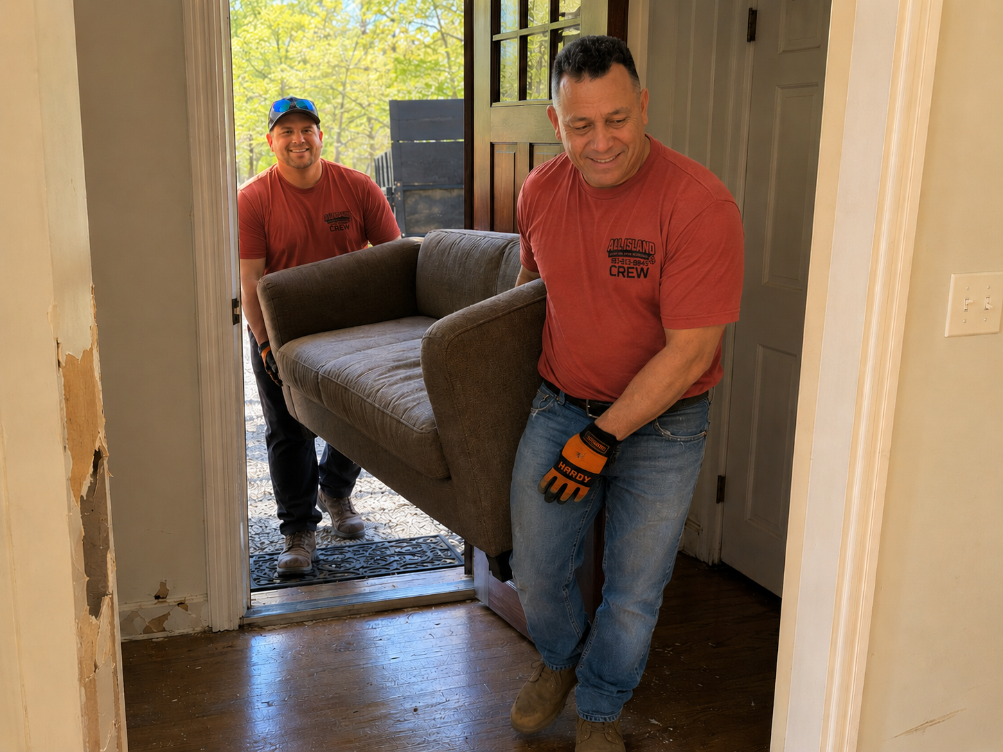 All Island crew carrying a couch out through a Long Island home's front door